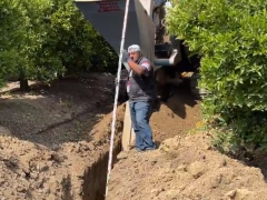 先进的农业机械，在柑橘园铺设排水管